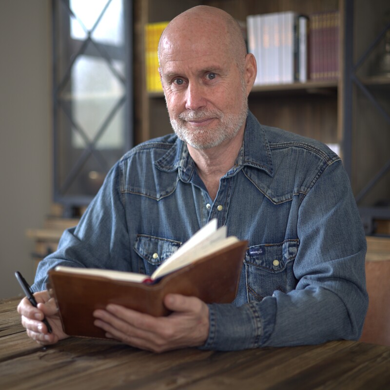 Michael Henderson Headshot holding a book