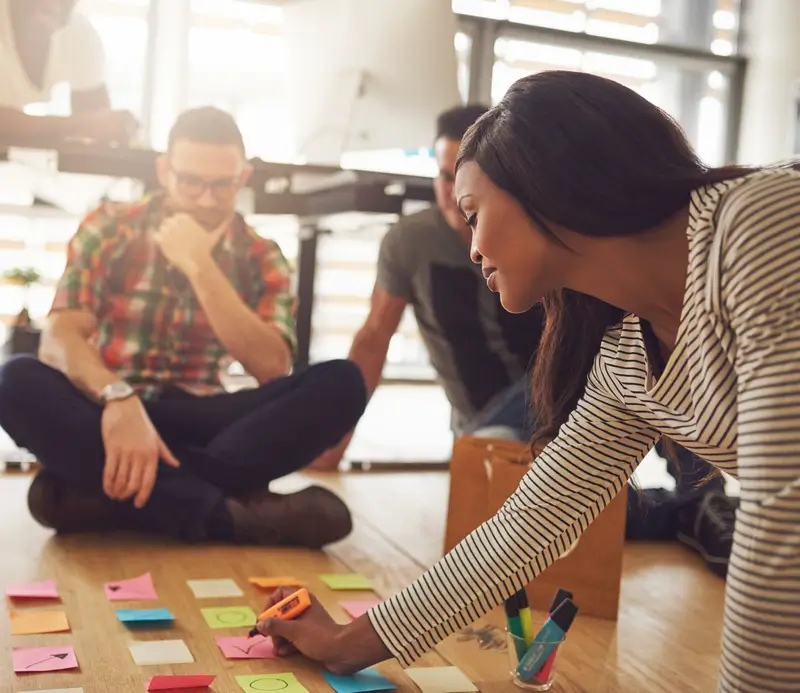 woman-writing-on-notes-for-workers-on-floor